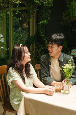 A smiling couple enjoying a cozy coffee date in a sunlit café.