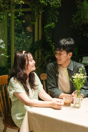 A warm photo of a smiling couple working together in a cozy home office filled with plants and personal touches.