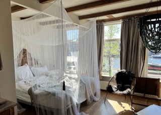 a bedroom with a canopy bed and a chair