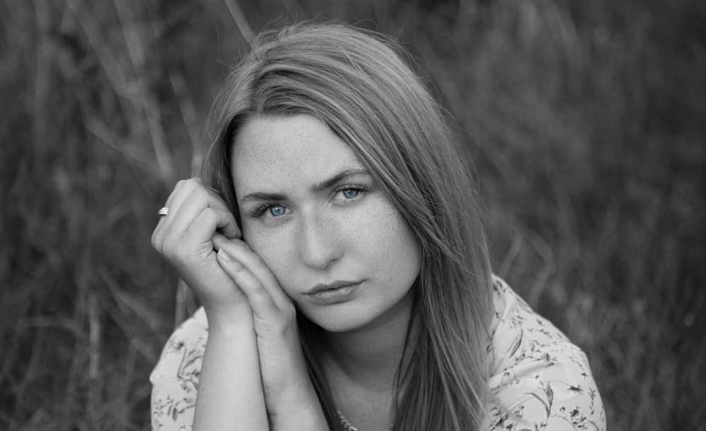 a woman with blue eyes sitting in a field