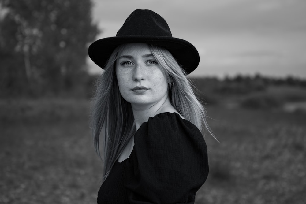 a woman wearing a black hat in a field