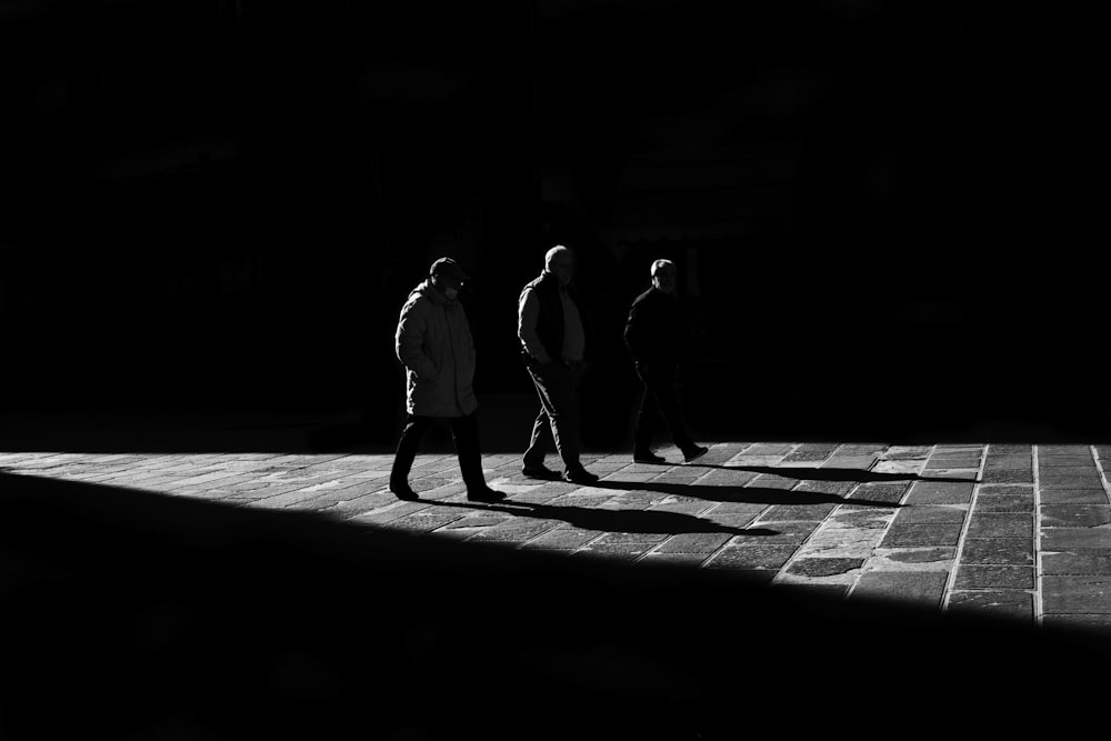 a group of people walking down a sidewalk