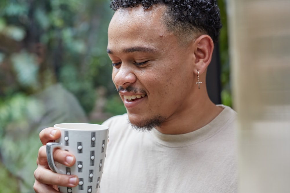 a man holding a coffee cup in his right hand