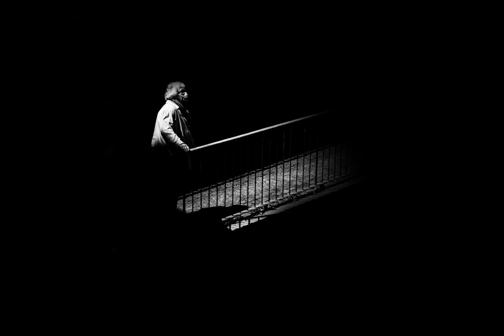 a man walking down a stair case in the dark
