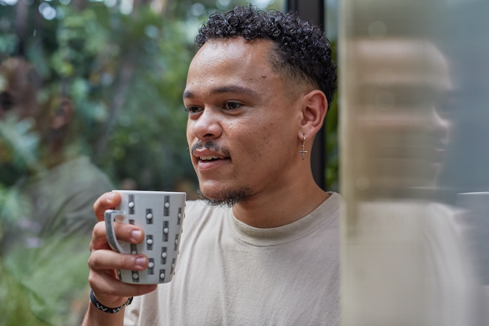 a man holding a coffee cup in his right hand