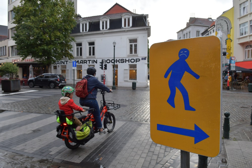 um homem andando de bicicleta com uma criança na garupa