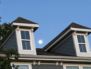 a full moon is seen through the windows of a house
