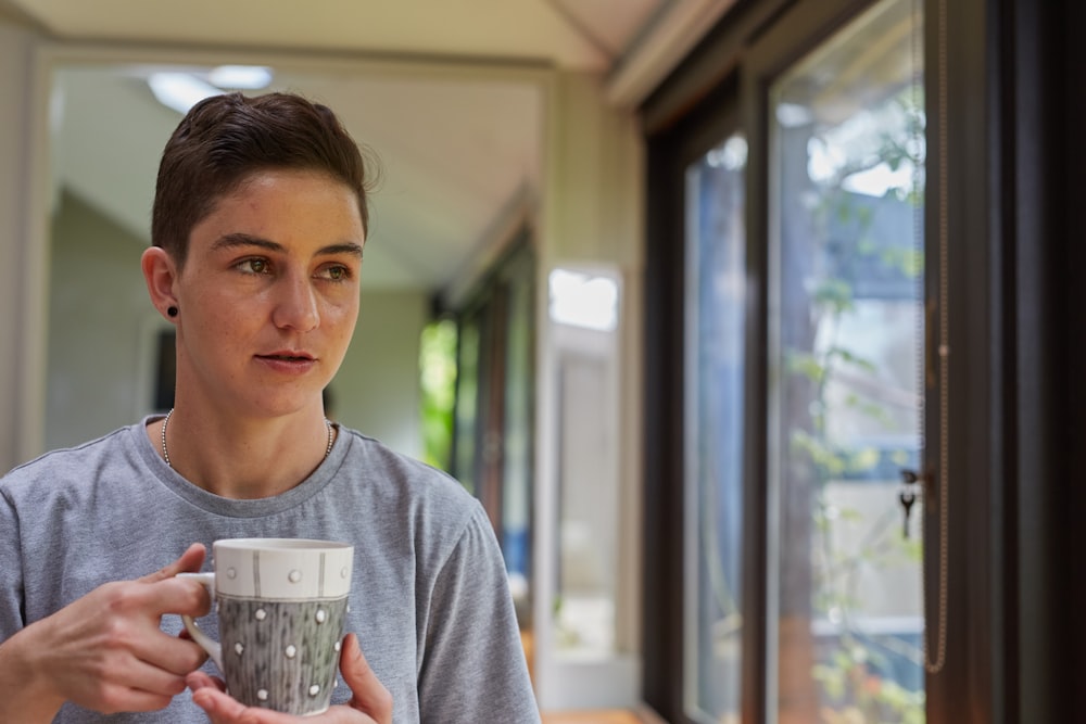 a young man holding a cup of coffee