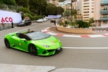 a green sports car driving down a street