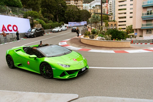 a green sports car driving down a street