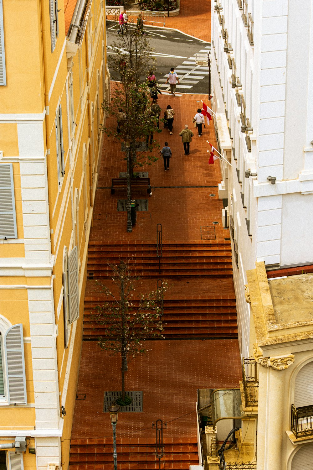 a group of people walking down a street next to tall buildings