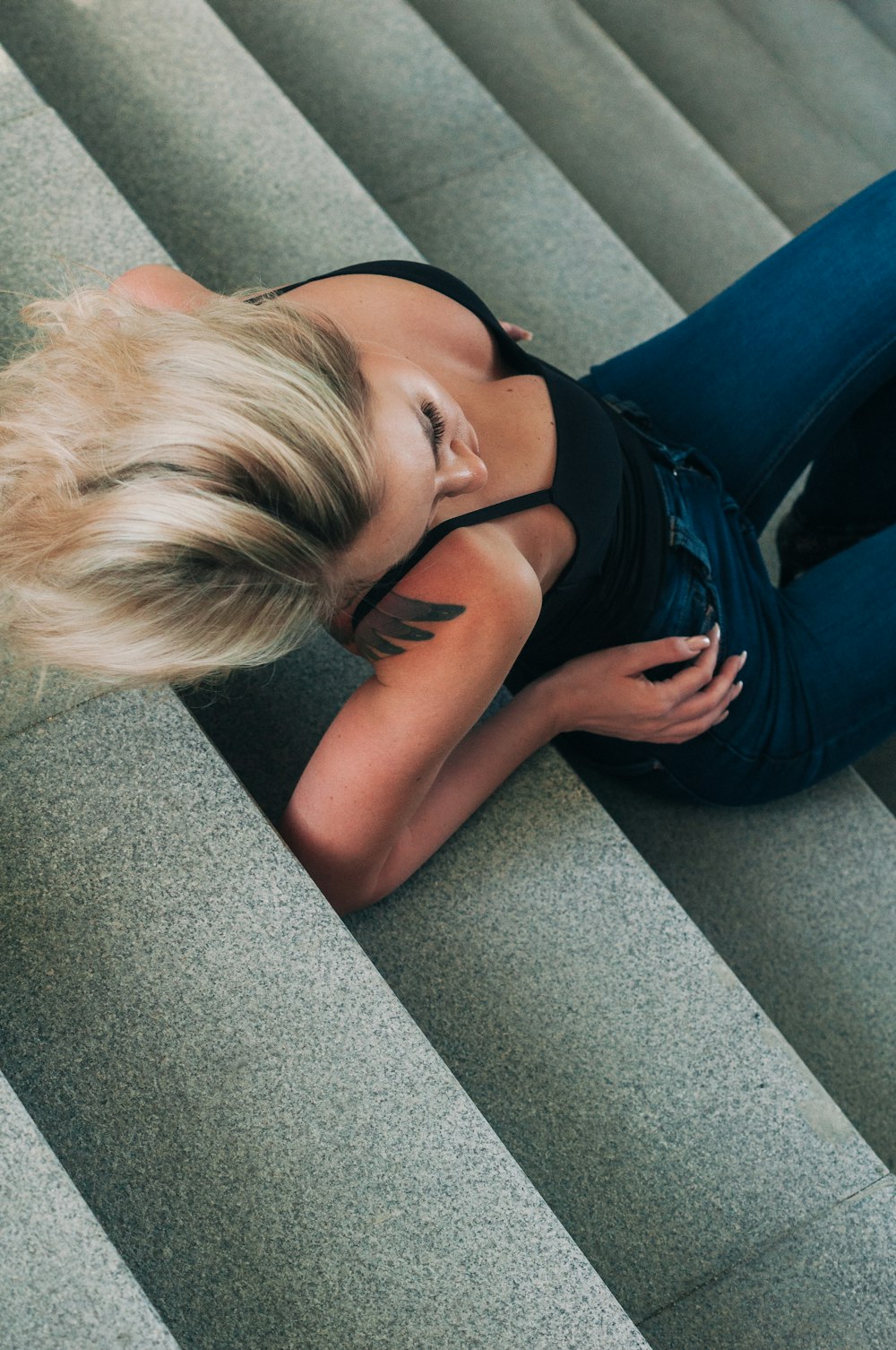 a blond woman sitting on top of a set of stairs