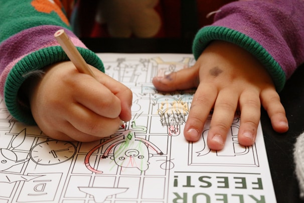 a child is drawing on a piece of paper