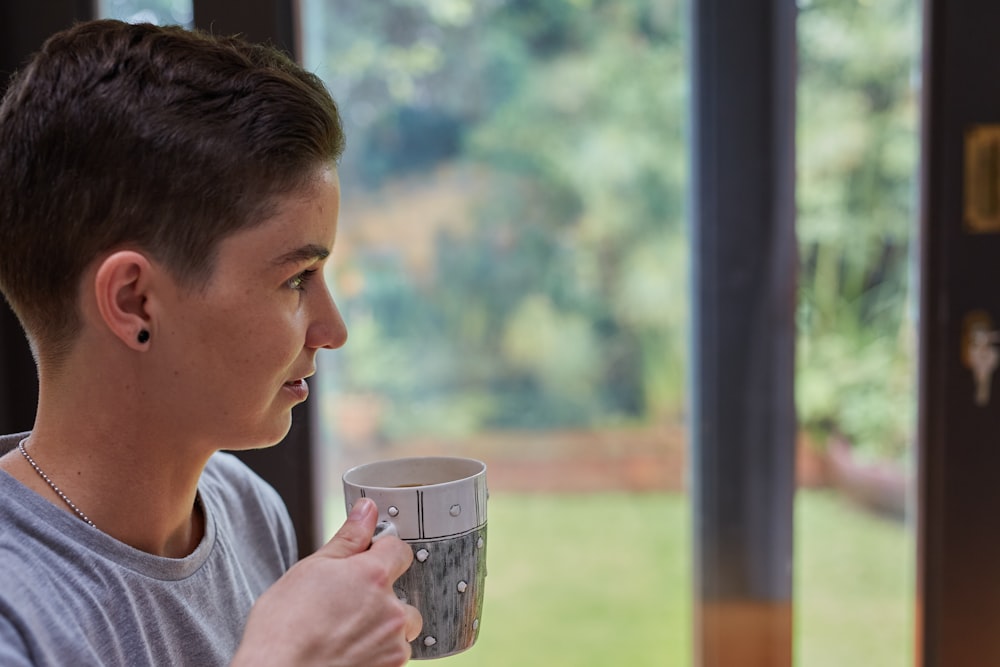 a young man holding a coffee cup in his hand