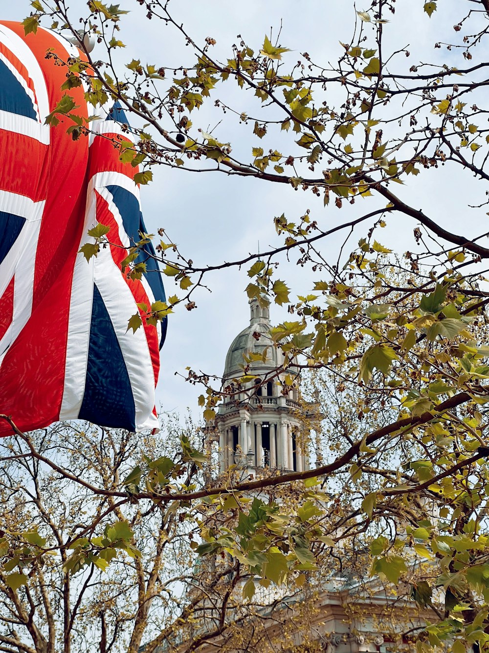 a british flag hanging from a tree in front of a building
