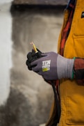 a person wearing gloves holding a pair of scissors