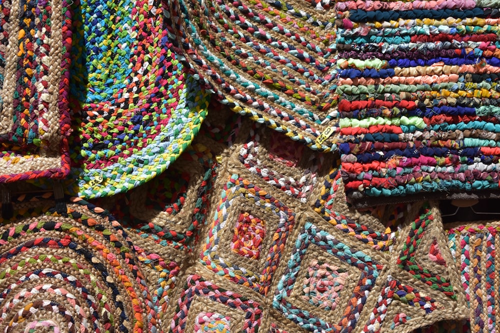 a pile of multicolored crocheted rugs sitting on top of each