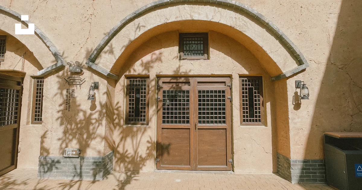 Tan Building Texture A tan building with two brown doors and two windows photo – Free ...