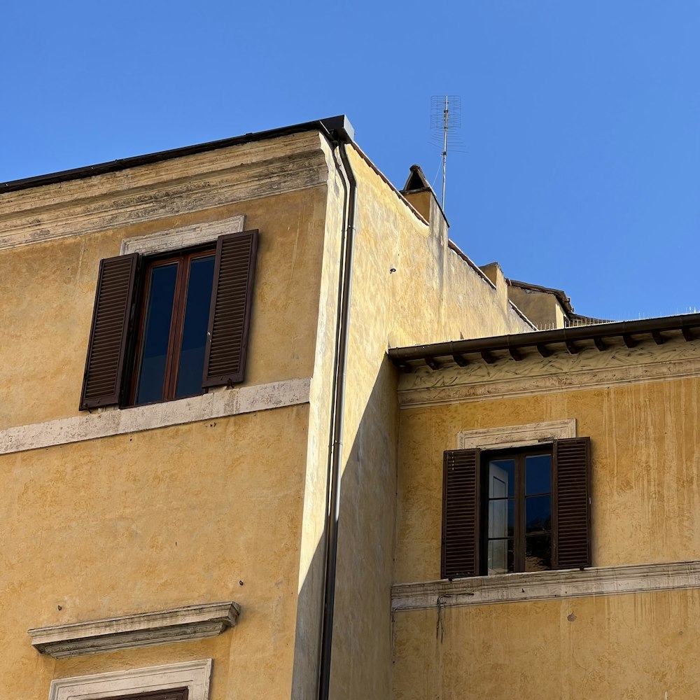 a building with two windows and a clock on the side of it