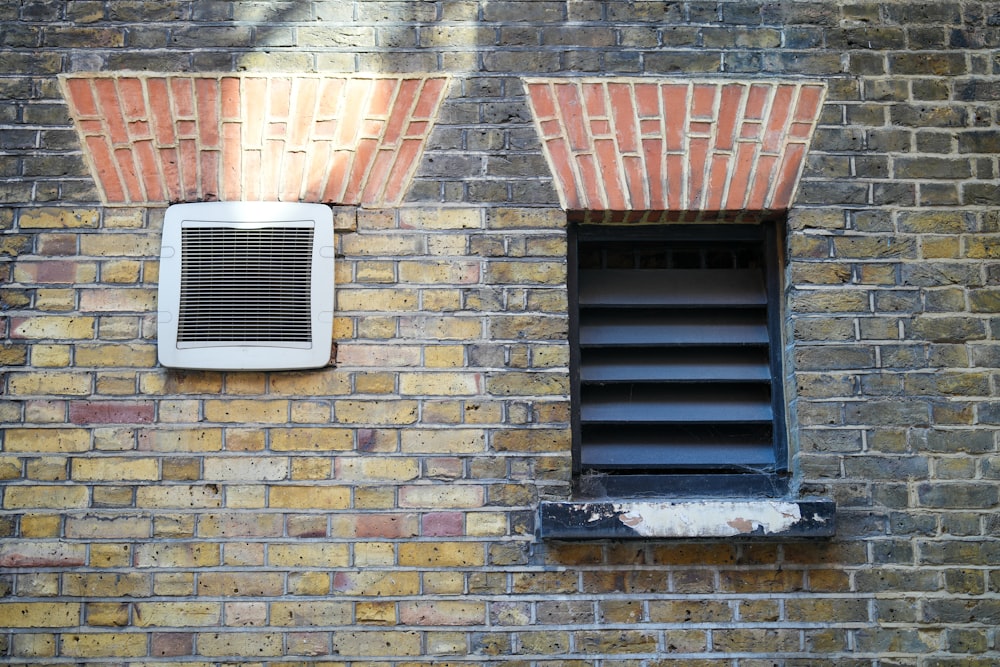 a brick wall with a window and a shutter