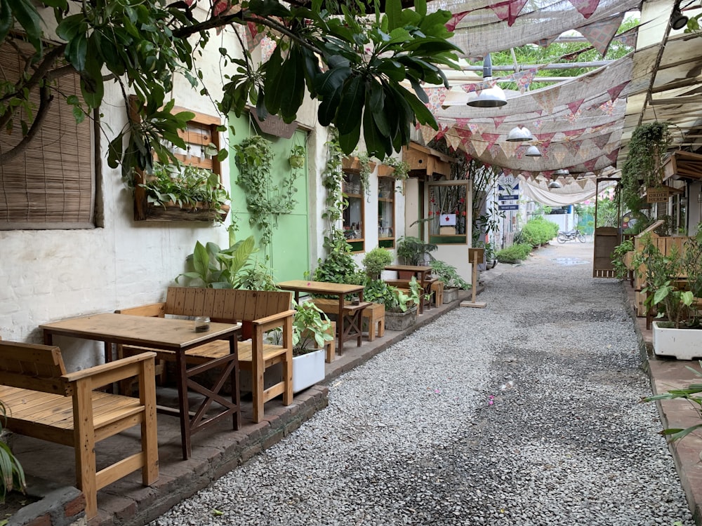 a walkway lined with tables and chairs under a canopy