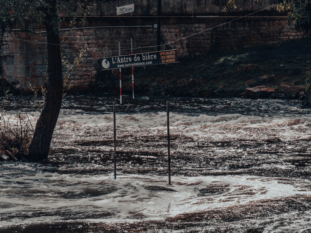 uma placa de rua sentada no meio de uma rua inundada