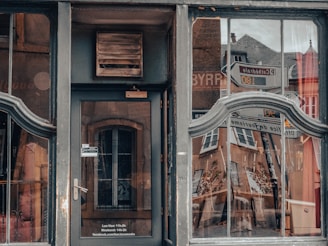 Close-up of a sleek commercial storefront glass door with aluminum framing reflecting a sunny city street.