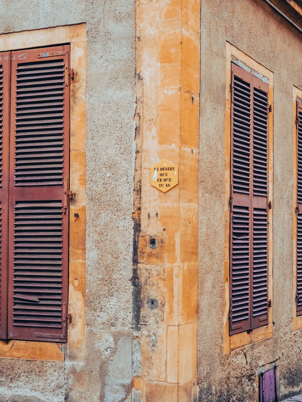 um edifício antigo com persianas e uma placa de rua