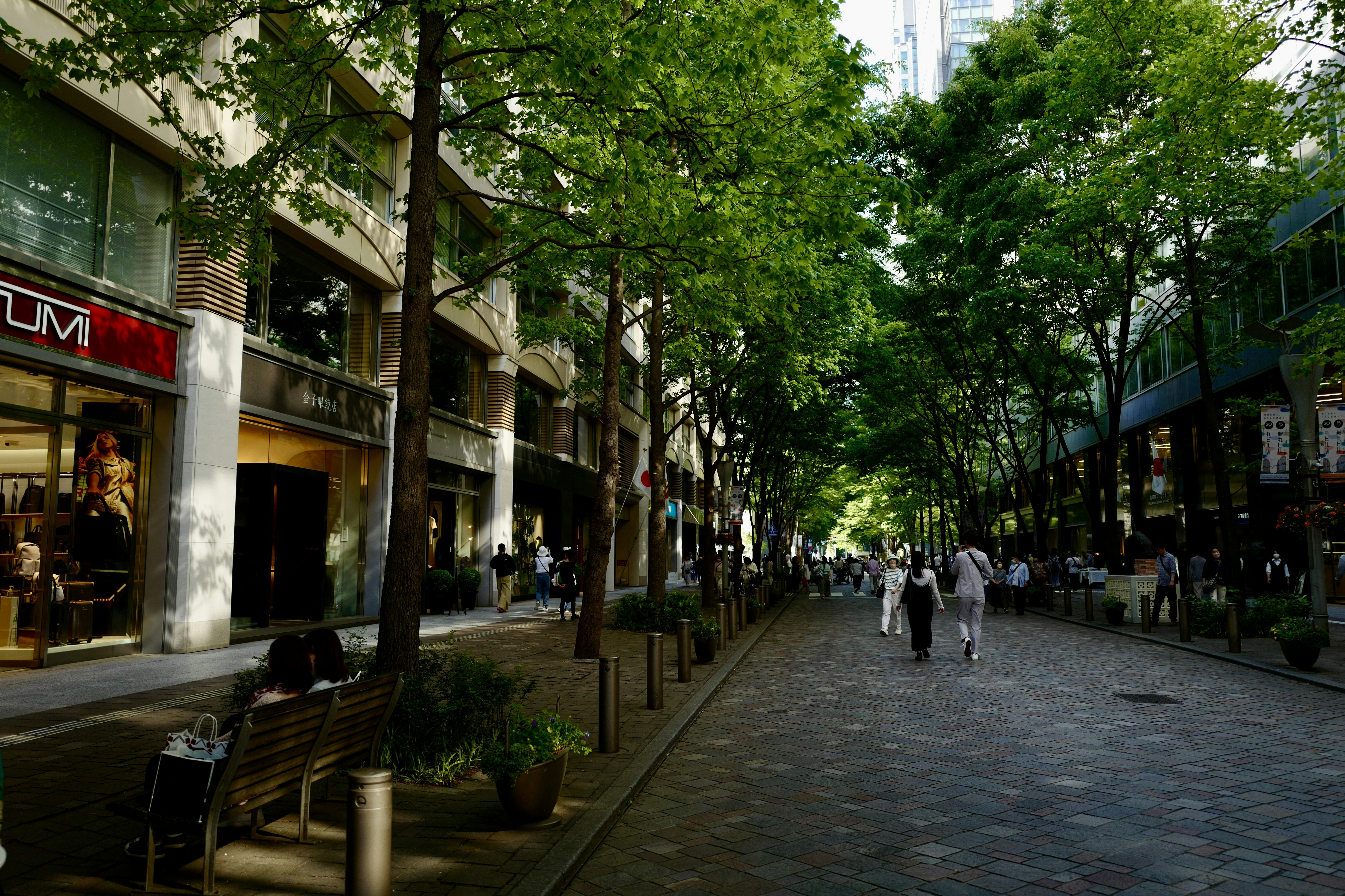 Eine Gruppe von Menschen, die eine Straße neben hohen Gebäuden entlang gehen