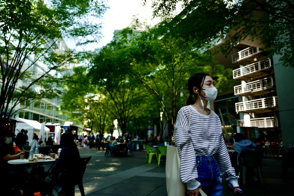 a woman wearing a face mask walking down a street