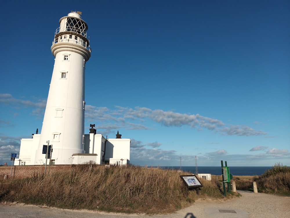 a large white lighthouse sitting on the side of a road