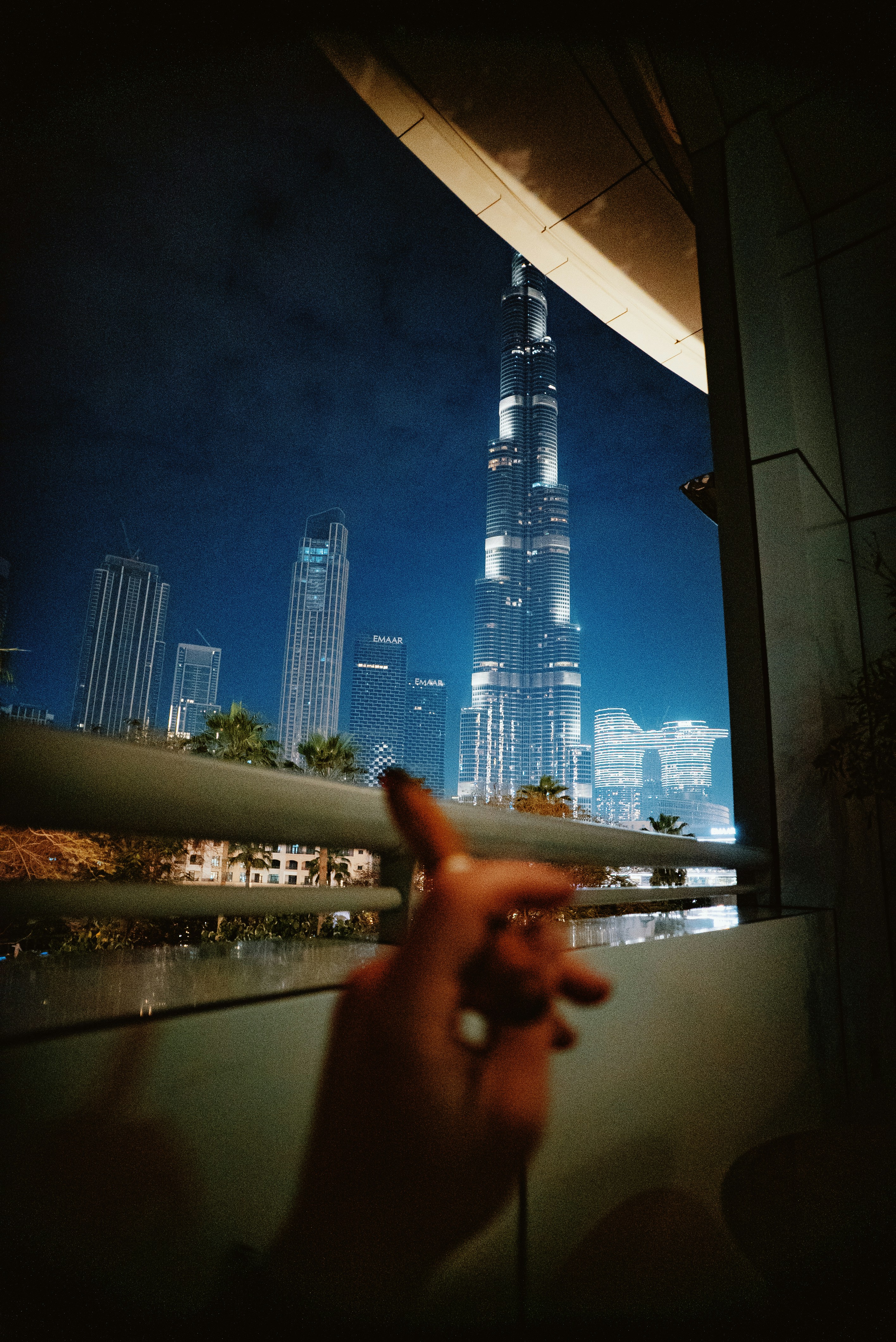 a person holding a cell phone in front of a cityscape