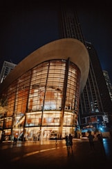 people are standing outside of a building at night