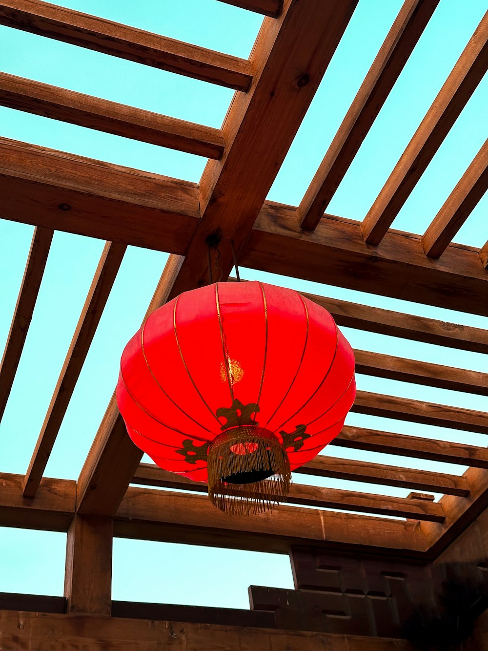 a red lantern hanging from a wooden roof