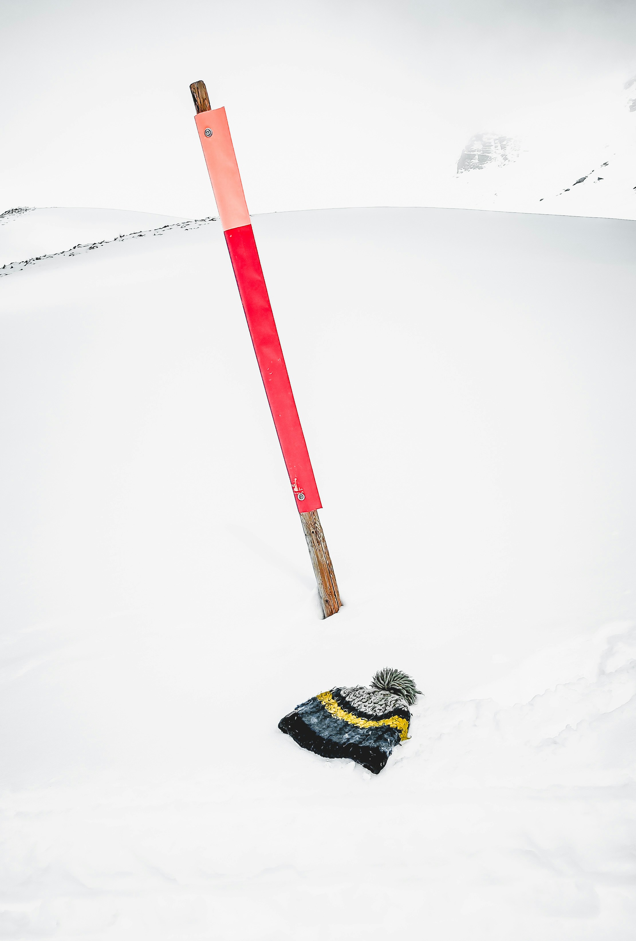 a pair of skis laying in the snow next to a pole