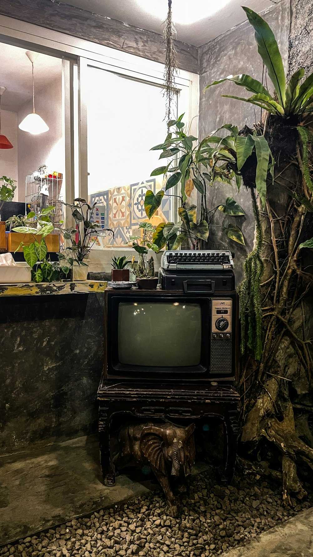 an old tv sitting on top of a table next to a potted plant