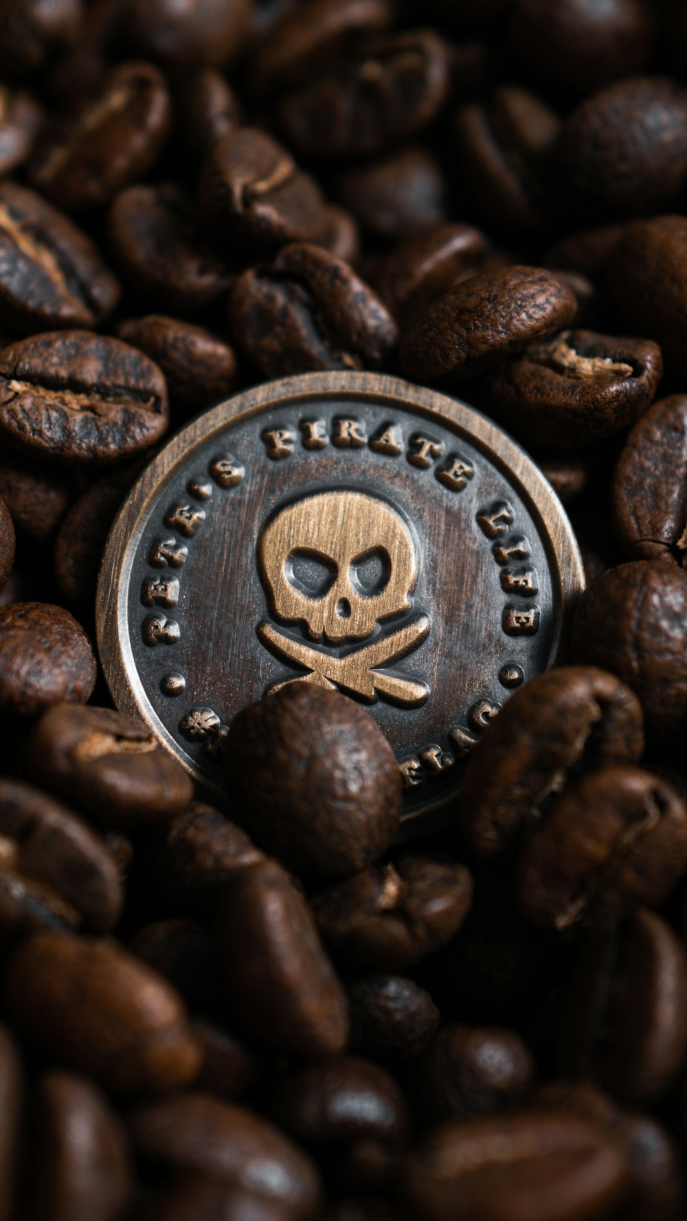 a skull and crossbone on top of a pile of coffee beans