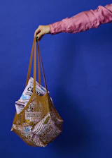 Close-up of hands holding a shopping bag filled with fresh groceries, symbolizing support.