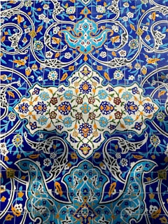 Vibrant blue and white ceramic tiles featuring Arabic calligraphy patterns.