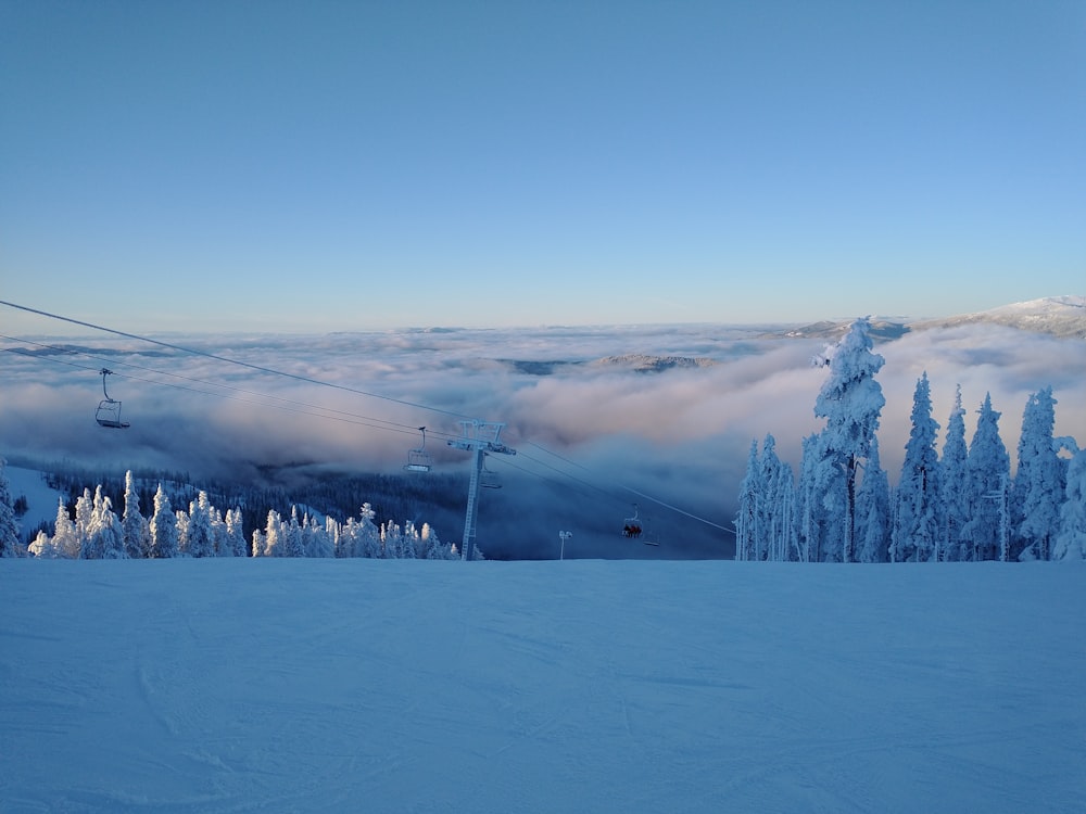 a snow covered ski slope with a ski lift in the background