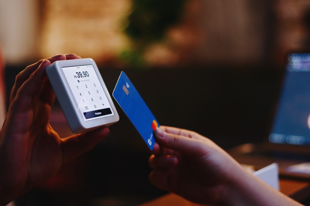 une personne détenant une carte de crédit et un téléphone cellulaire