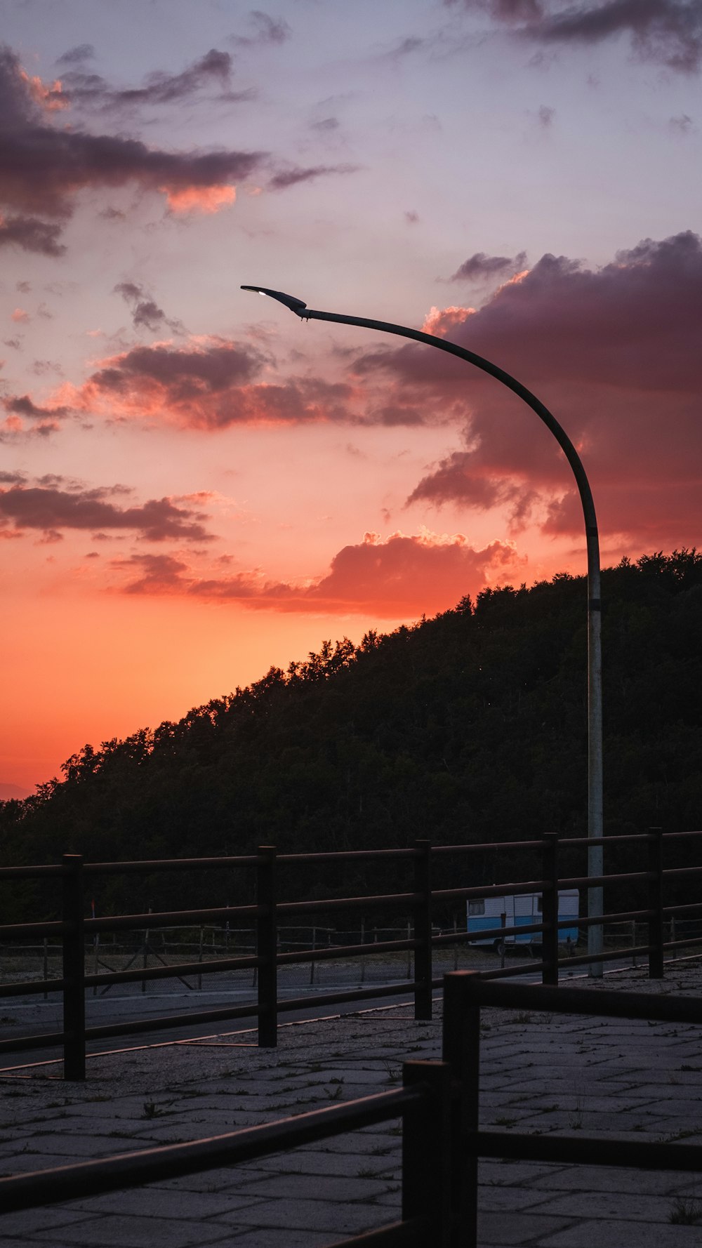 a street light in front of a sunset