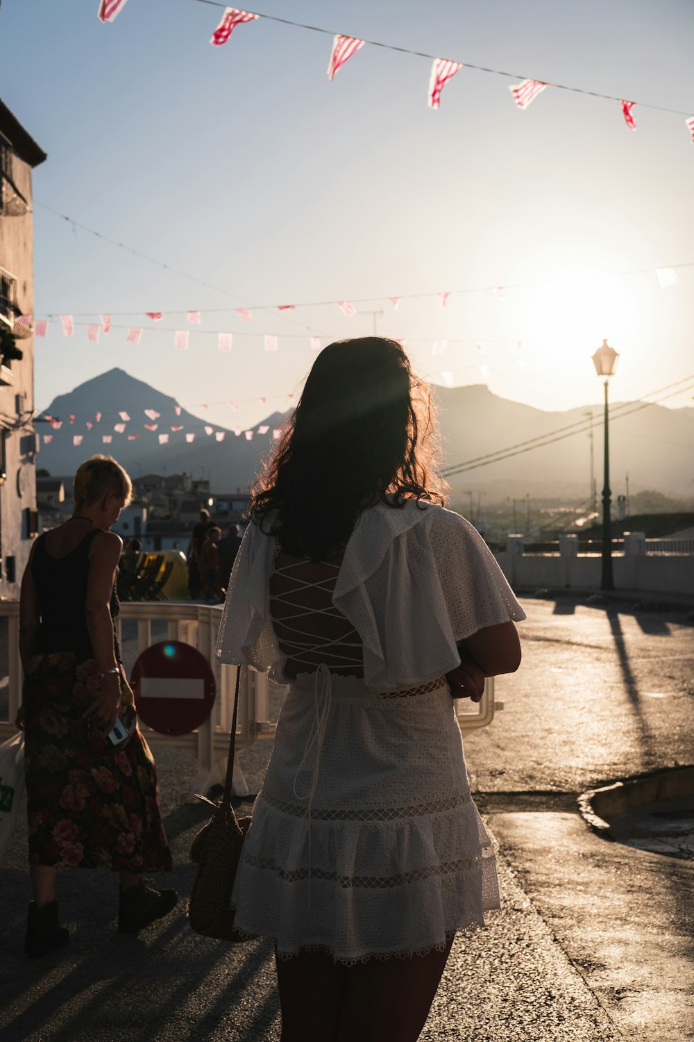 Una donna in un vestito bianco che cammina lungo una strada