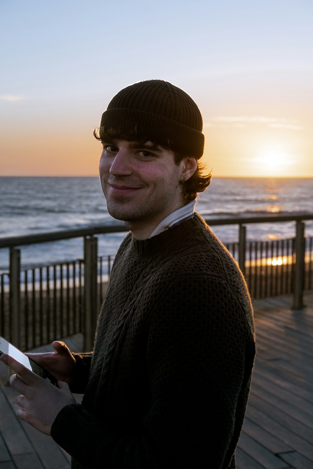 a man standing on a pier next to the ocean