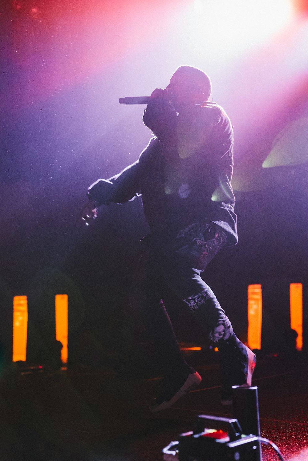 a man standing on top of a stage holding a microphone