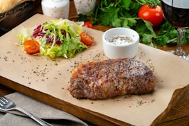 a steak and a salad on a cutting board