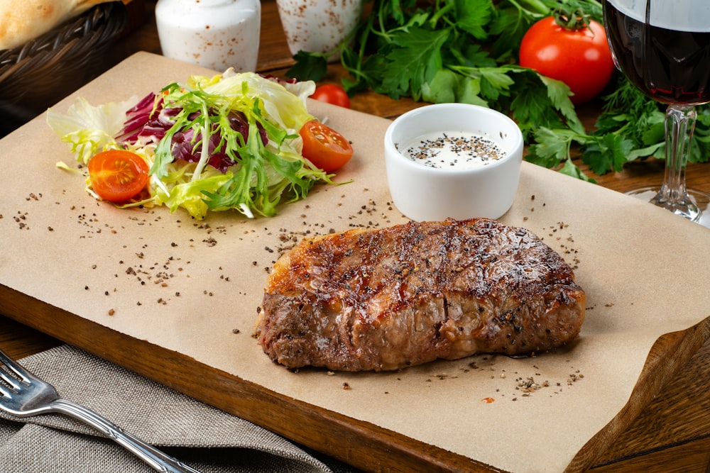 a steak and a salad on a cutting board