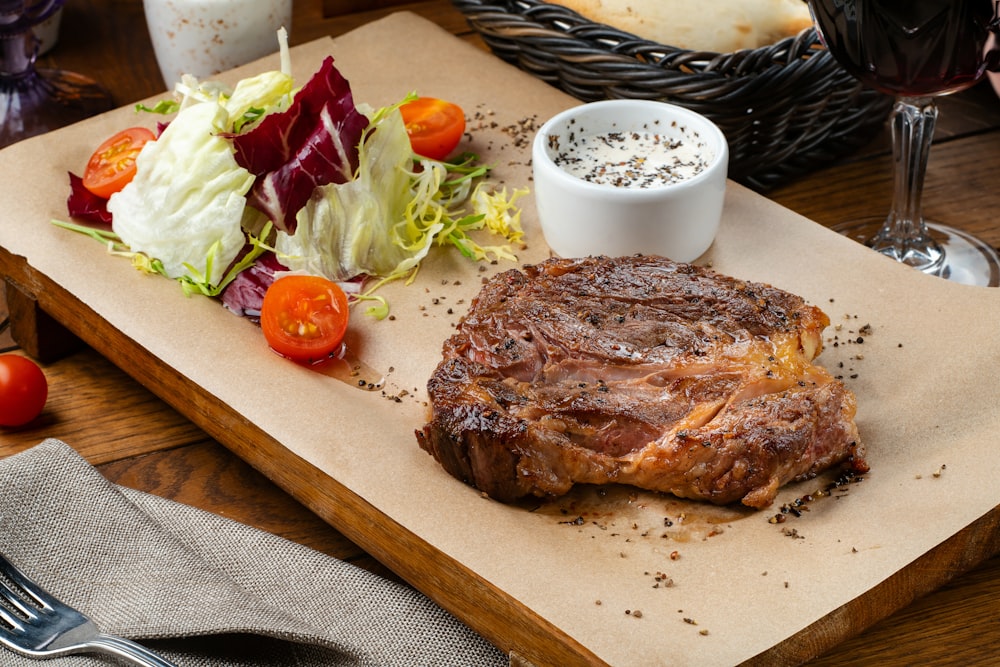 a steak and a salad on a cutting board