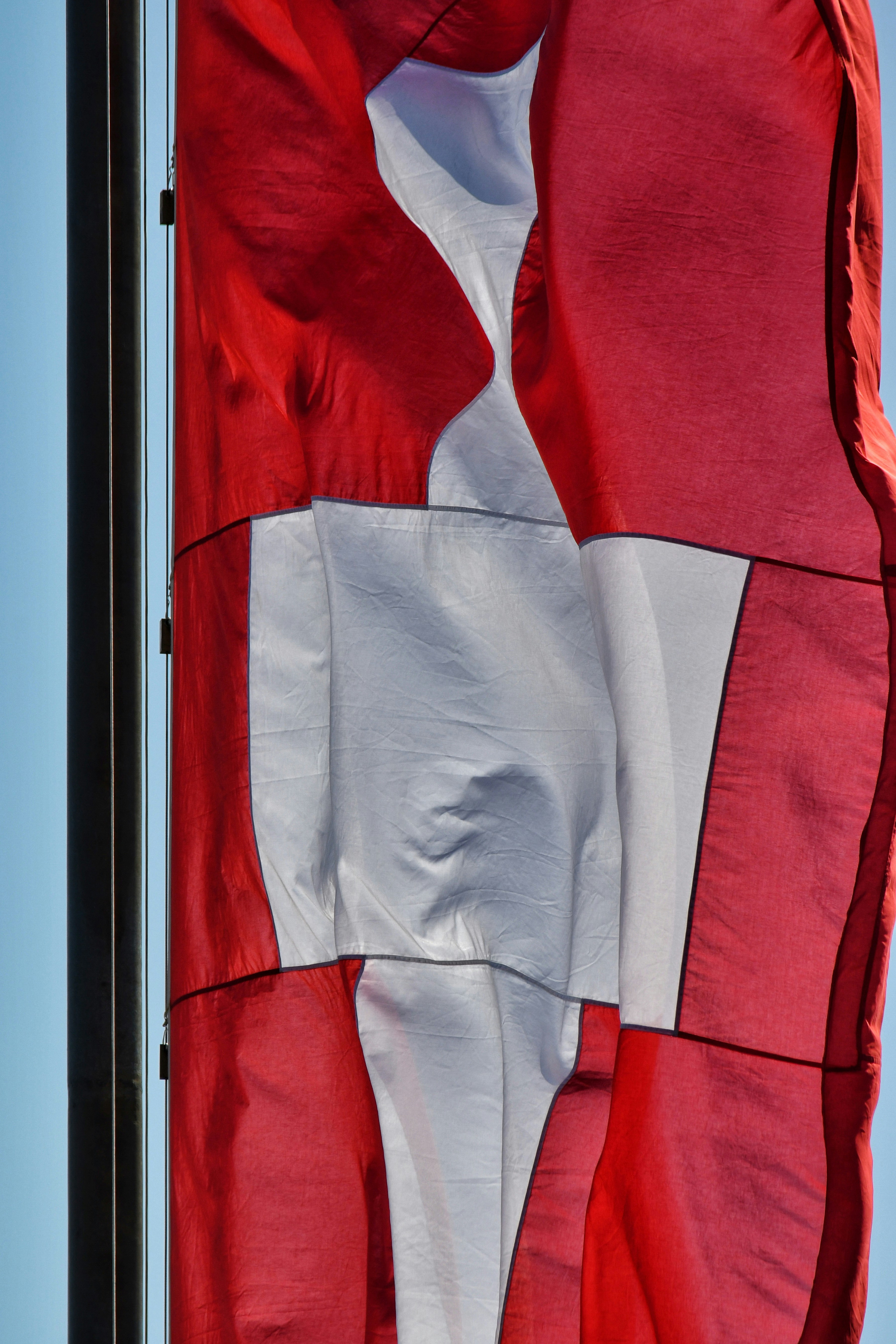 A large red and white flag flying in the sky photo – Free Magglingen ...