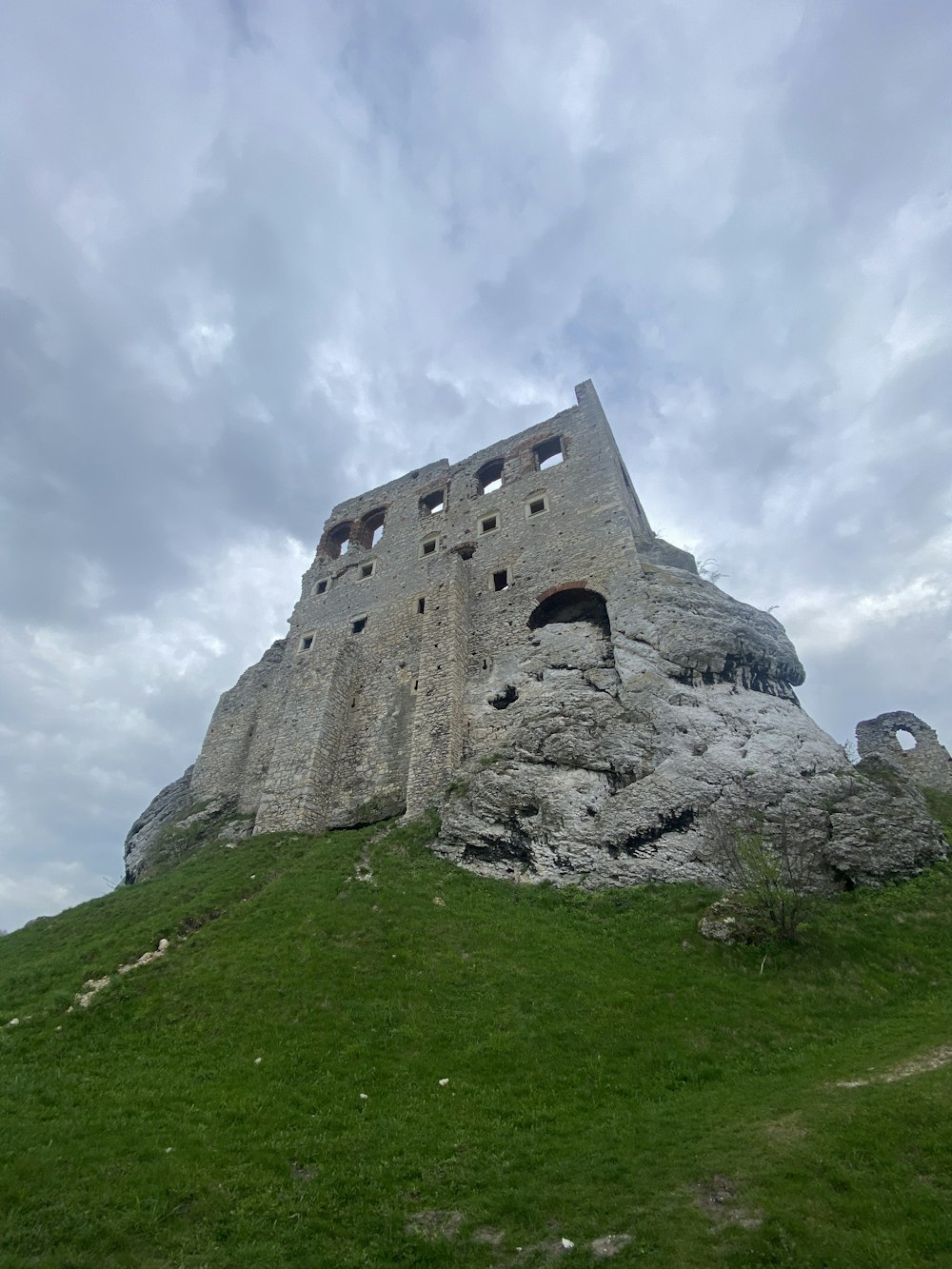 a large stone building sitting on top of a lush green hillside